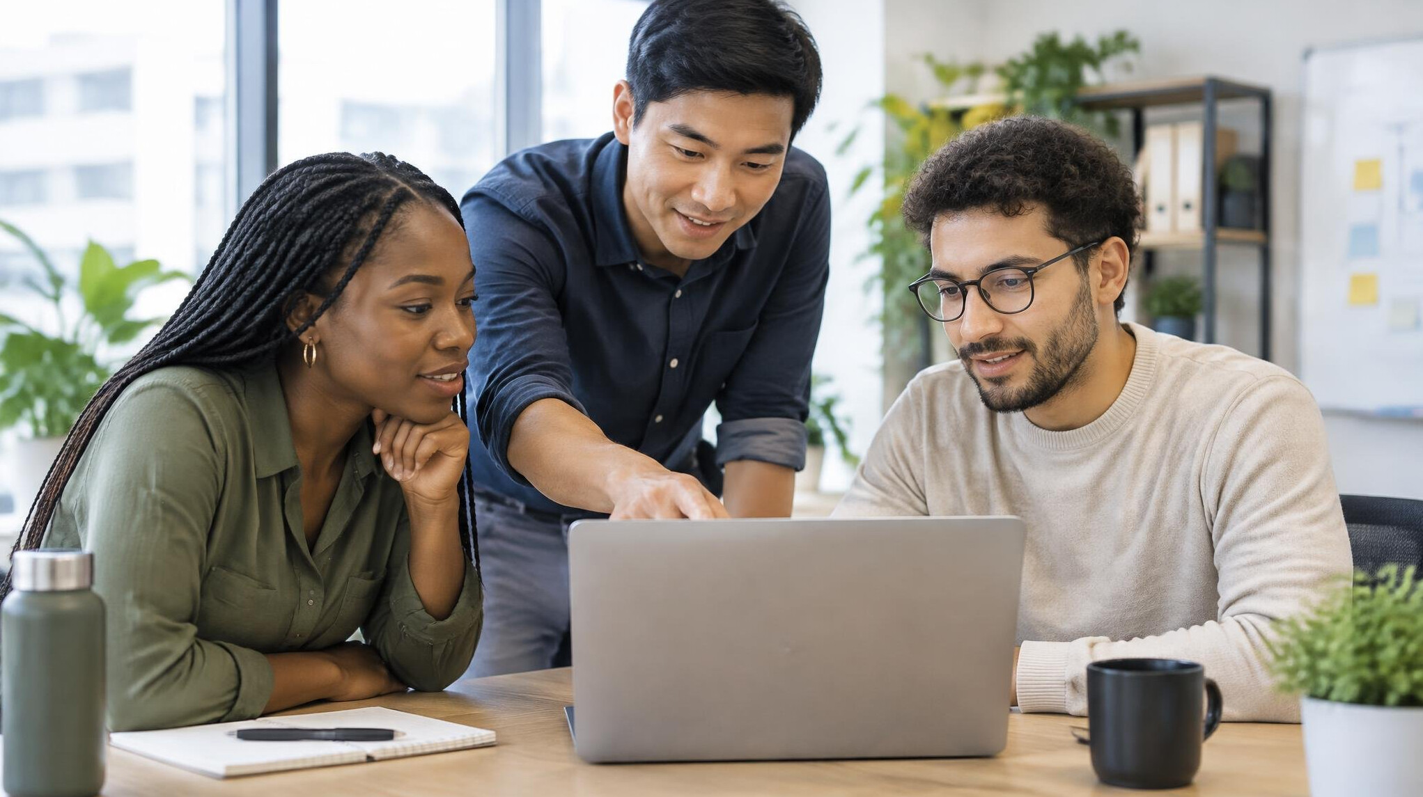 Small group of colleagues discussing around a laptop